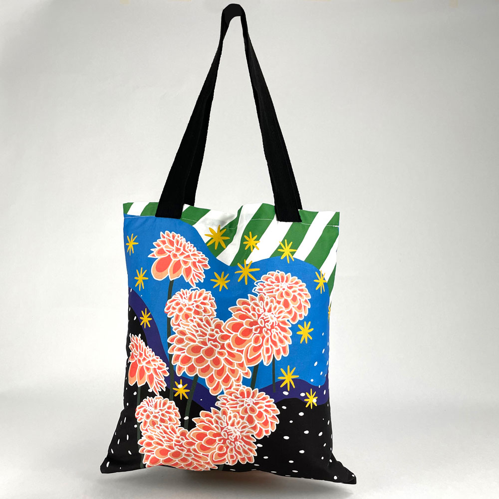 Full view of a custom printed tote bag with a modern floral design and black straps.