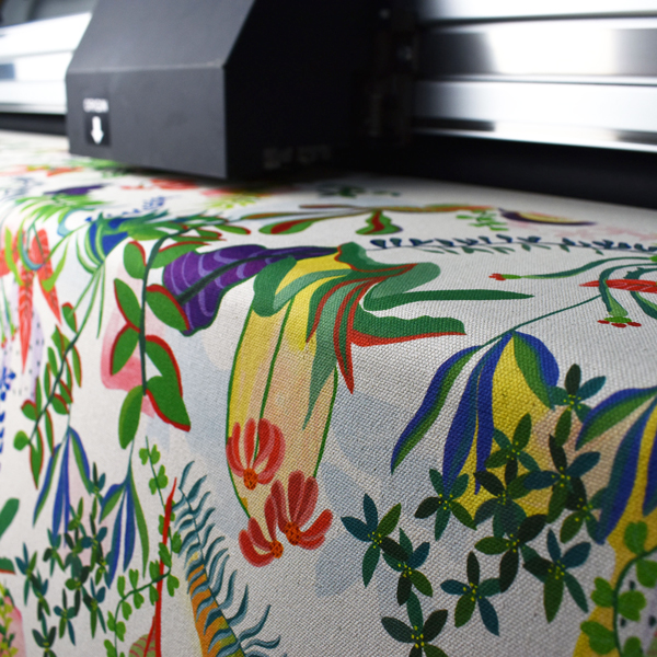 A custom fabric design in the process of being printed on a digital textile printer.