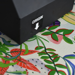 a textile printer close up printing floral fabric on a cotton canvas