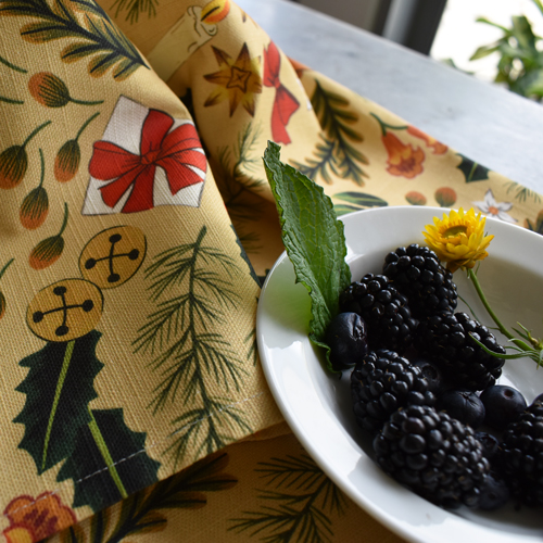 Christmas Print Fabric on a table with berries in a bowl