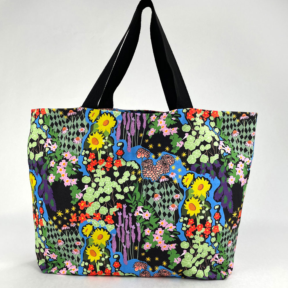 Front shot of opened Harper Tote showing a full cover print of a bright floral design on a black background.