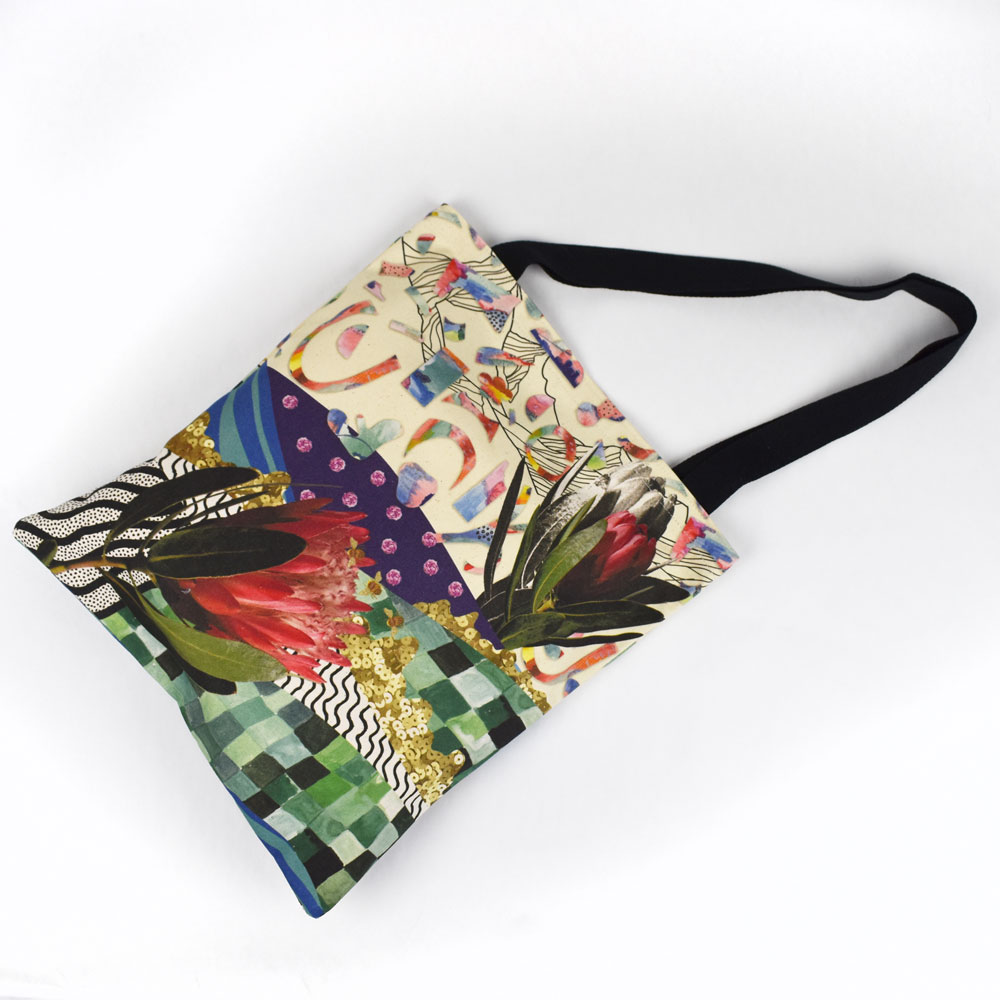 a tote bag laying flat that has an all over custom print of a floral collage